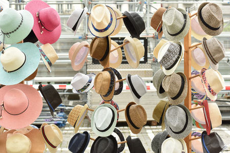 Hats are sold in the store. Clothes on the storefront.