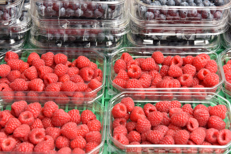 Fresh raspberries in a container. Fruit in the market.の写真素材