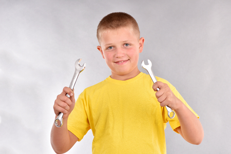Boy with a wrench. The guy in the yellow t-shirt.の写真素材