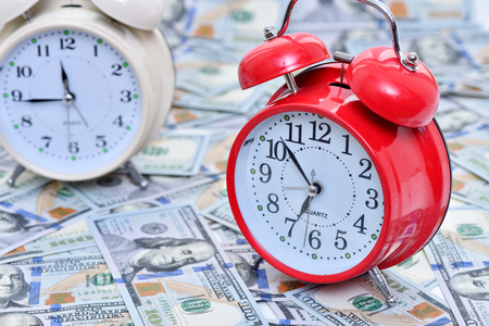 Time to make money. Alarm clock and dollars.