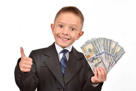 The boy holds dollars. Young businessman on a white background.の写真素材