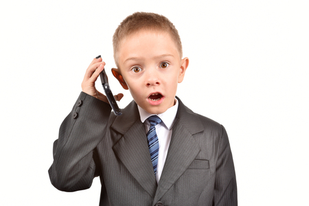 The boy is talking on the phone. A child in a suit.の写真素材