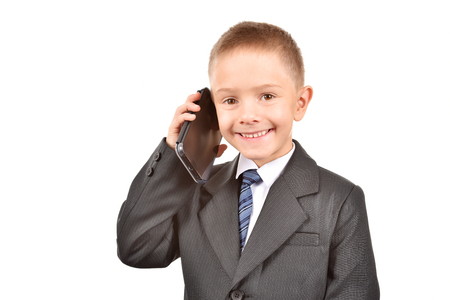 The boy is talking on the phone. A child in a suit.の写真素材