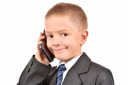 The boy is talking on the phone. A child in a suit.の写真素材