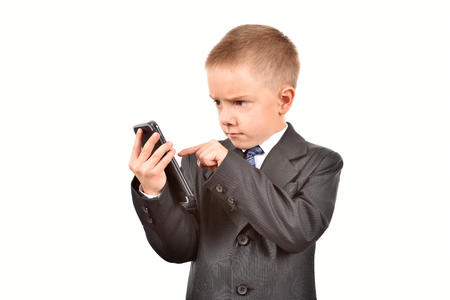 The boy is talking on the phone. A child in a suit.の写真素材