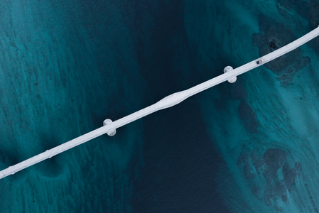 Aerial shot of a bridge over sea strait. Visible depth with blue and green colours near Tromso. Sommaroy, Norwayの写真素材