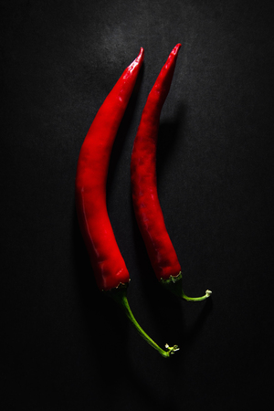 Red chilli peppers on a black background