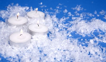 beautiful white candles and snow on blue backgroundの写真素材