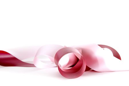 long pink ribbon curled up on white backgroundの写真素材