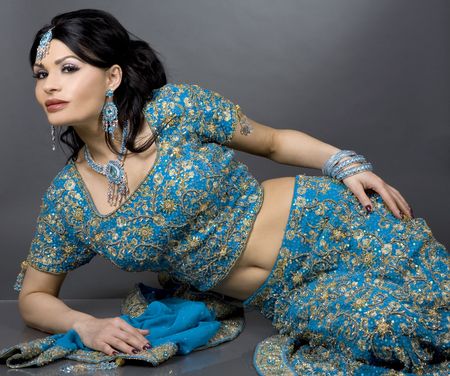 pretty brunette wearing traditional indian outfit on greyの写真素材