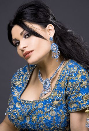 pretty brunette wearing traditional indian outfit on darkの写真素材