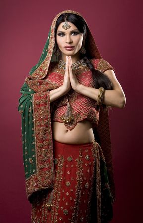 beautiful indian woman wearing bridal outfit on redの写真素材