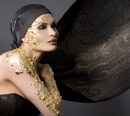 pretty brunette wearing gold outfit and matching makeupの写真素材