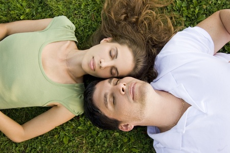 couple in the park relaxing on their backsの写真素材