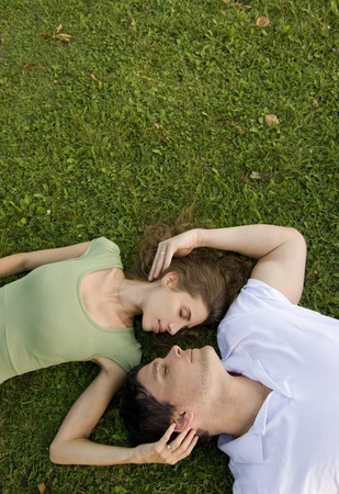 couple in the park relaxing on their backsの写真素材