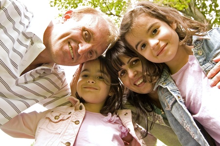 family of four in the park having fun togetherの写真素材