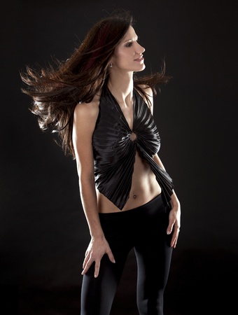 beautiful brunette having fun on black backgroundの写真素材