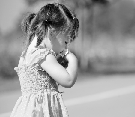 girl toddler is having fun smelling flower in the summerの写真素材