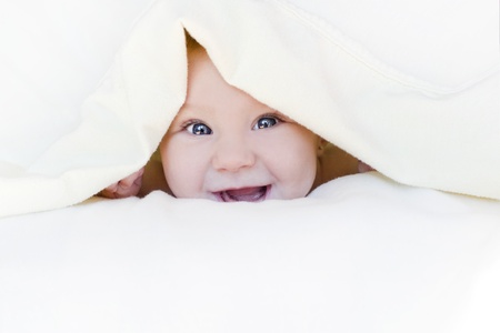 baby girl is wrapped in white blanketの写真素材