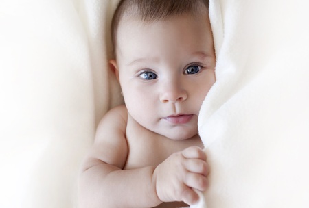 baby girl is wrapped in white blanketの写真素材