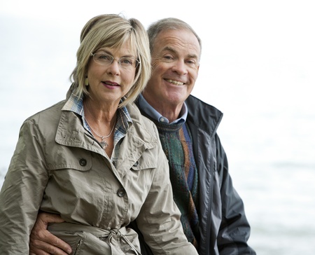 older casual couple sitting in the grass outdoorsの写真素材