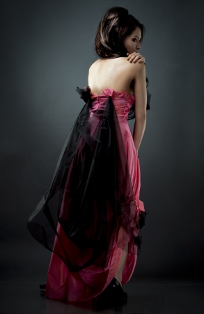 beautiful asian brunette wearing jewellery and fashin dress on dark backgroundの写真素材