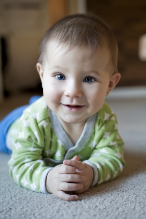 baby girl is playing on the carpetの写真素材