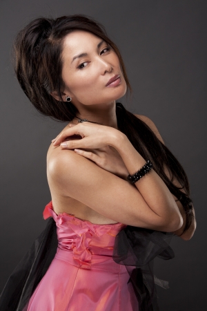 beautiful asian brunette wearing jewellery and fashin dress on dark backgroundの写真素材