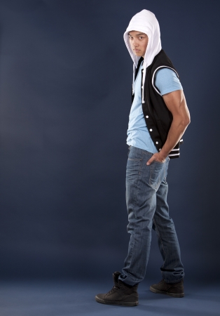 casual man wearing blue tshirt and jeans on dark backgroundの写真素材