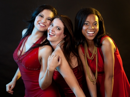 beautiful three women having fun during party on dark backgroundの写真素材