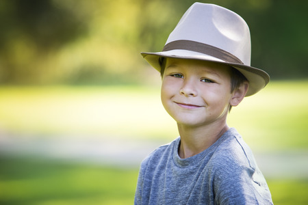 cuacasian boy smiling wearing a hat in the parkの写真素材