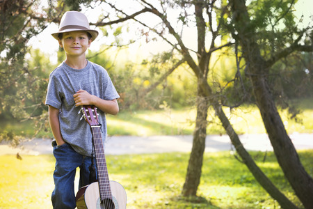 cuacasian boy with guitar in the park outdoorsの写真素材