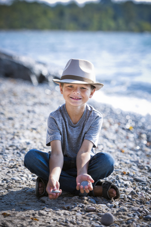 cuacasian boy smiling wearing a hat on the beachの写真素材