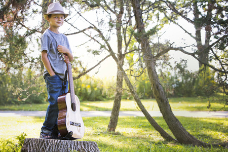 cuacasian boy with guitar in the park outdoorsの写真素材