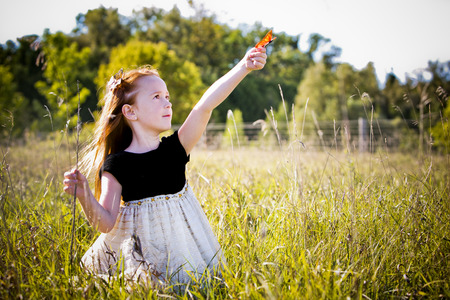 caucasian girl smiling and playing in the parkの写真素材