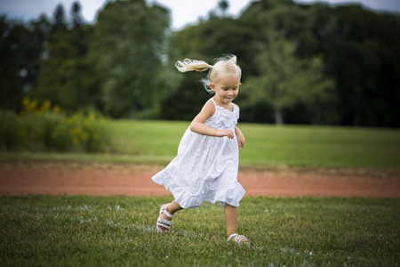 caucasian girl smiling and playing in the parkの写真素材
