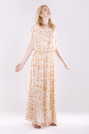blond woman wearing beige dress on white backgroundの写真素材