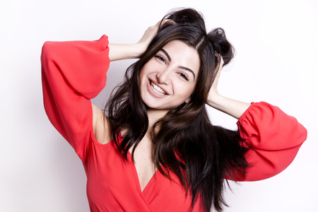 pretty brunette with long hair on white background wearing red