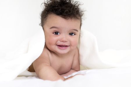 adorable baby boy wrapped with blanked on white backgroundの写真素材