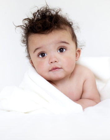 adorable baby boy wrapped with blanked on white backgroundの写真素材