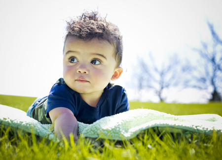 adorable baby boy outdoors posing on green grassの写真素材