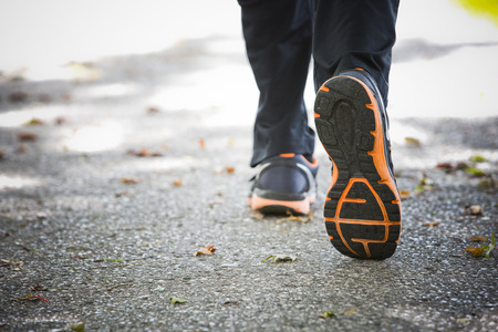 close up feet with running shoes jogging on the asphalt in the parkの写真素材
