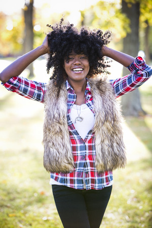 ethnic woman wearing fashion fall outfit outdoors int he parkの写真素材