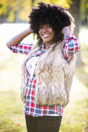 ethnic woman wearing fashion fall outfit outdoors int he parkの写真素材