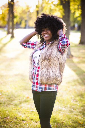 ethnic woman wearing fashion fall outfit outdoors int he parkの写真素材