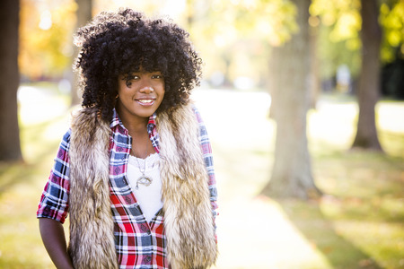 ethnic woman wearing fashion fall outfit outdoors int he parkの写真素材