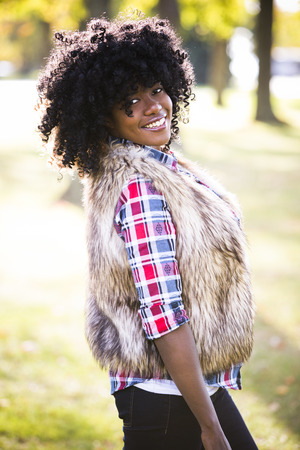 ethnic woman wearing fashion fall outfit outdoors int he parkの写真素材