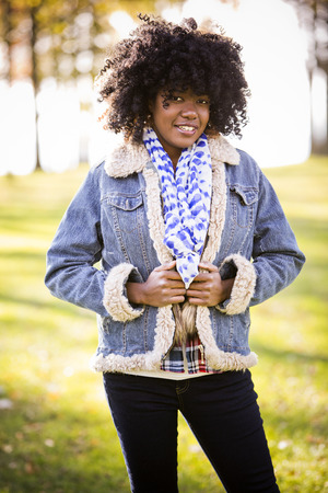 ethnic woman wearing fashion fall outfit outdoors int he parkの写真素材