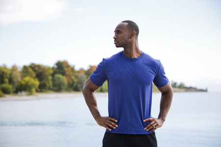 young black man wearing athletic wear on the beachの写真素材