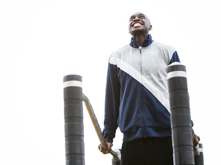 Active black man in training suit exercising at outdoor gymの写真素材